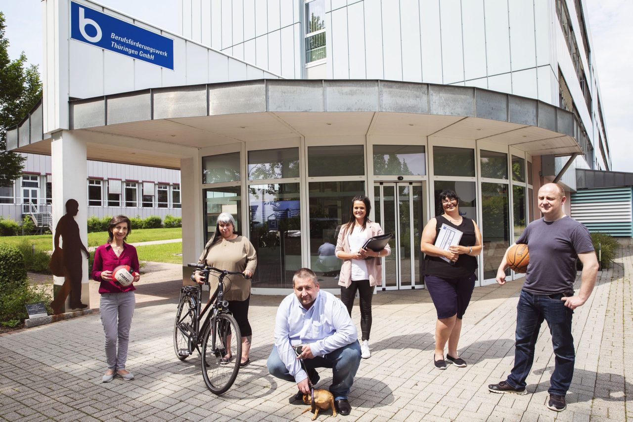 Eine Menschengruppe steht vor dem Gebäude des Berufsförderungswerk Thüringen GmbH