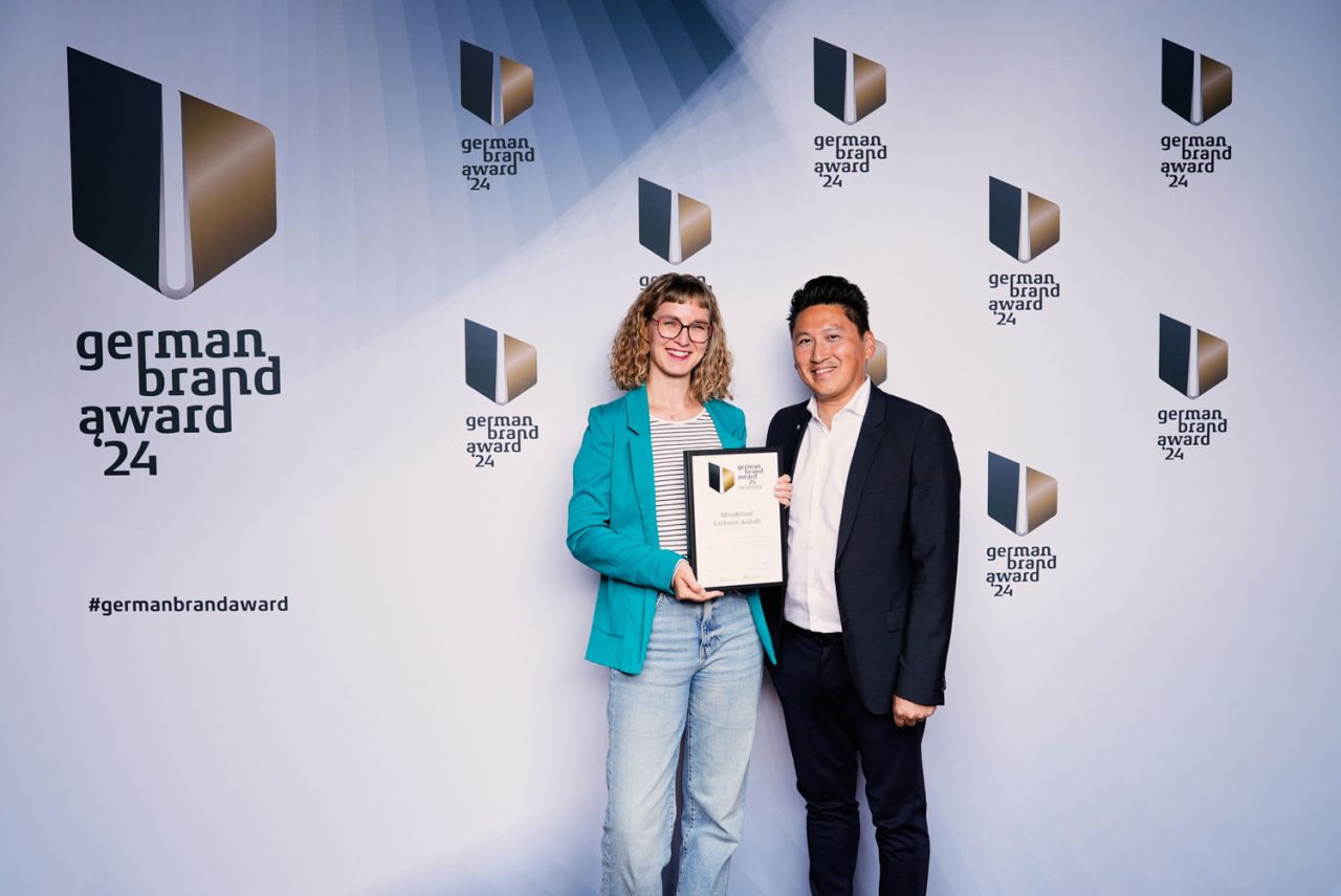 Sarah Pukall und Hoang Huy Tran vor der Fotowand des German Brand Awards 2024